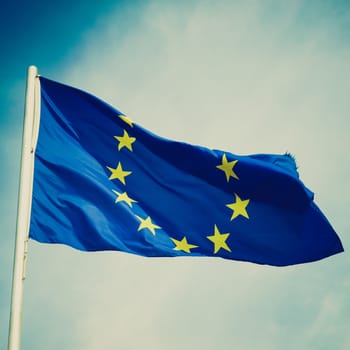 Vintage retro looking Flag of Europe over a blue sky