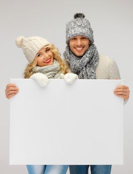 picture of family couple in a winter clothes holding blank board