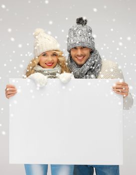 picture of family couple in a winter clothes holding blank board