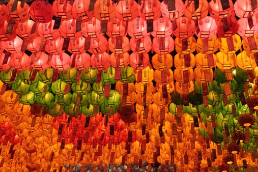 Many red, yellow and green glowing lanterns on Buddha's birthday