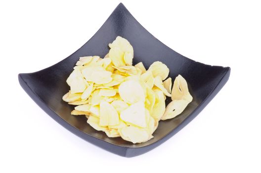Slices of Dried Garlic in Black Square Bowl isolated on white background