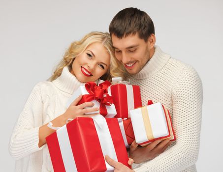 picture of romantic couple in a sweaters with gift boxes