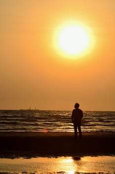 Silhouette man on beach with sunset sky background, Thailand