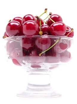 Ripe fresh cherry in the chrystal glass isolated on white background