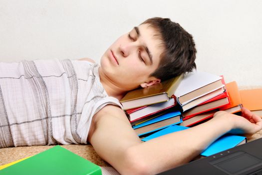 Tired Teenager sleeping on the Books at the Home