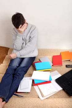 Sad Student on the Sofa with the Books at the Home