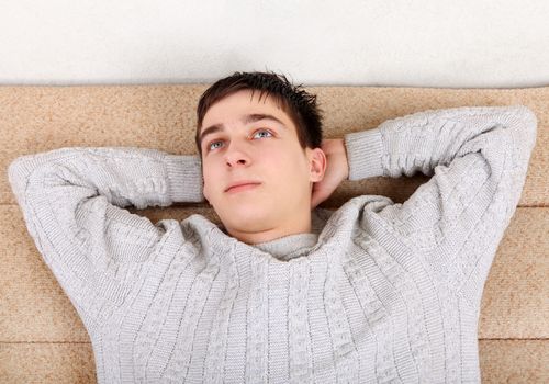 Teenager resting and dreamimg on Sofa at the Home