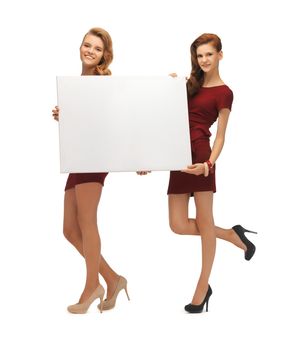 picture of two teenage girls in red dresses with blank board