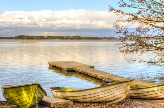 Rowboats and a pier by the lake under the low clouds