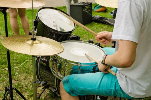 musical drums and cymbals. Guy hand with wooden sticks on a drum