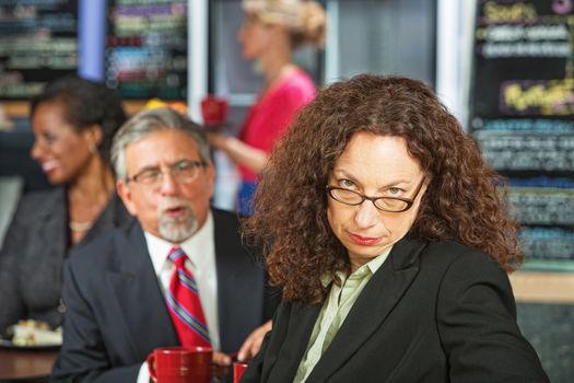Man bothering frustrated business woman in coffee house