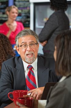 Business man with beard and glasses talking to coworker