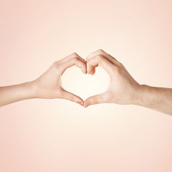close-up of woman and man hands showing heart shape