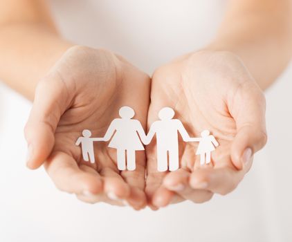 close up of womans cupped hands showing paper man family