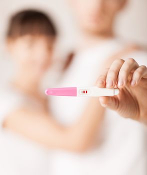 close up of woman and man hands with pregnancy test