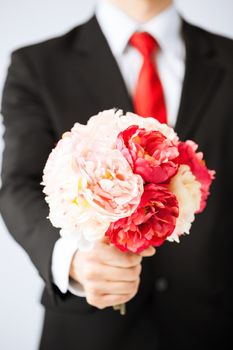 close up of young man giving bouquet of flowers.