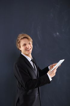 Young, handsome man of success on black chalkboard background