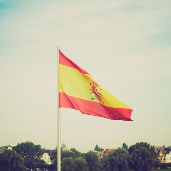 Vintage retro looking Flag of Spain over a blue sky