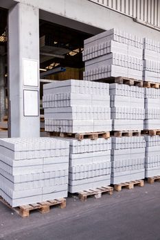 Cement building blocks stacked on pallets used for transportation and distribution at a hardware depot, warehouse or on a construction site