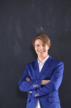 Young, handsome man of success on black chalkboard background