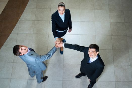 team of three businessmen clasped her hands together, a symbol of teamwork