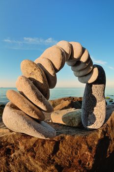 Arch of pebbles on the sea boulder