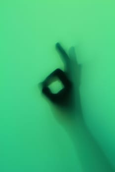 Hand silhouette on green glass
