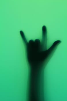 Hand silhouette on green glass