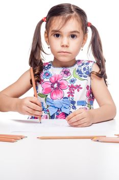 young girl with drawig pencil at white table