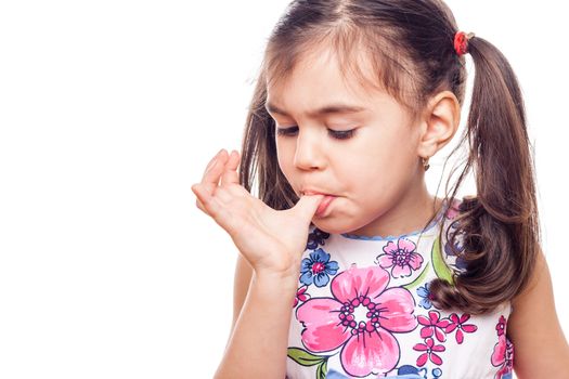 young girl on white background licking finger