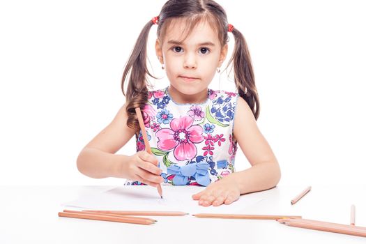 young girl with drawig pencil at white table