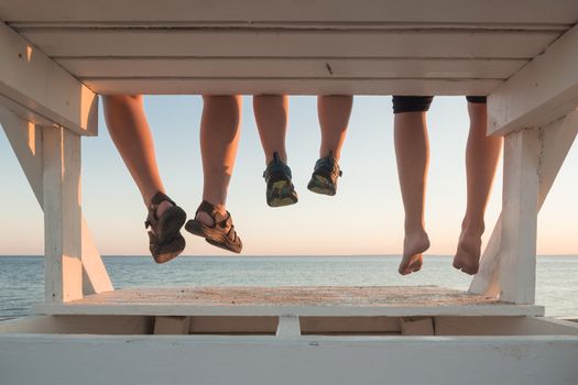 Family with their feet hanging at sunset in Cape Cod