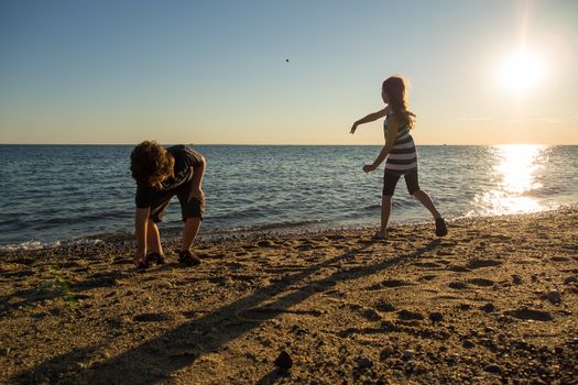 Children playing on the beach in Cape Cod at sunset