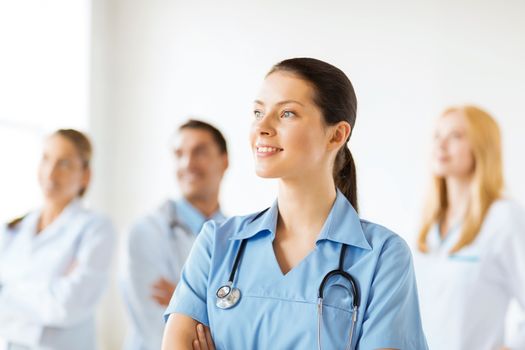 attractive female doctor or nurse in front of medical group