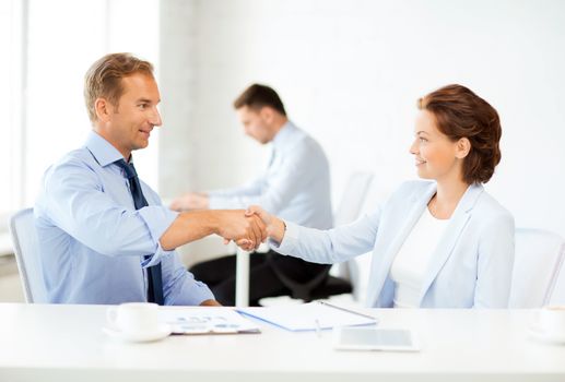 picture of businessman and businesswoman shaking hands in office