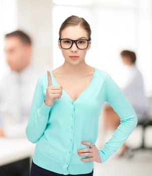 young girl wearing eyeglasses showing warning gesture