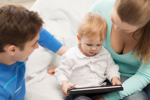 happy parents and adorable baby with tablet pc