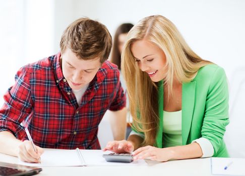 education - smiling students doing mathematics at school