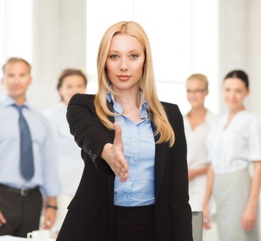 woman with an open hand ready for handshake in office