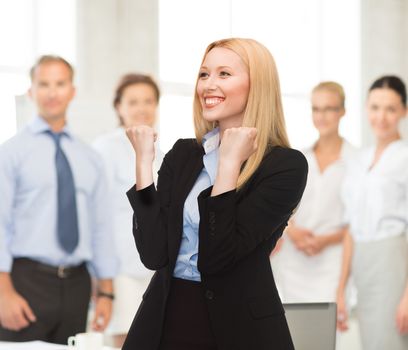 picture of young happy woman with hands up in office