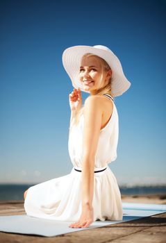 fashion and lifestyle concept - beautiful woman in hat enjoying summer outdoors