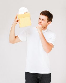 picture of man in white t-shirt with gift box