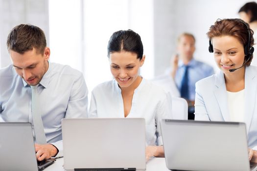 picture of group of people working with laptops in office