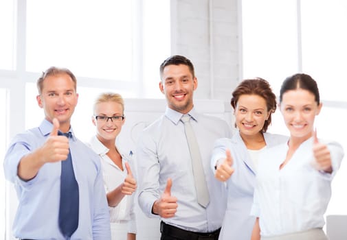 picture of happy business team showing thumbs up in office