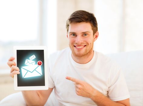 education, communication and internet concept - man holding tablet pc with email sign at home