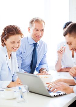 smiling businessman with team on meeting in office