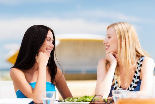 summer holidays and vacation - girls in cafe on the beach