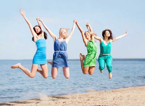 summer holidays and vacation - girls jumping on the beach