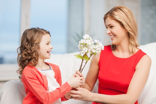 home and family - happy mother and daughter with flowers