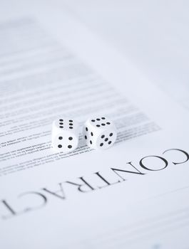 picture of contract paper with gambling dices